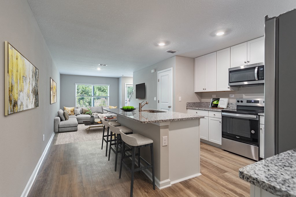 an open kitchen and living room with an island and stools