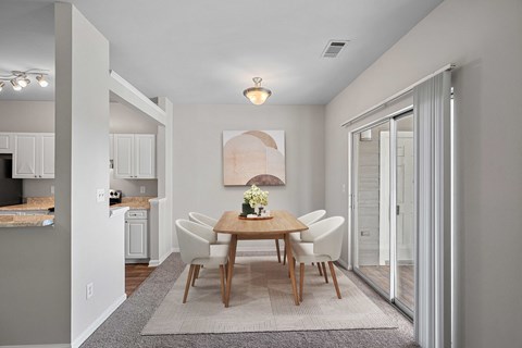 A dining room with a table set for four at Hawthorne Bridford in Greensboro, NC