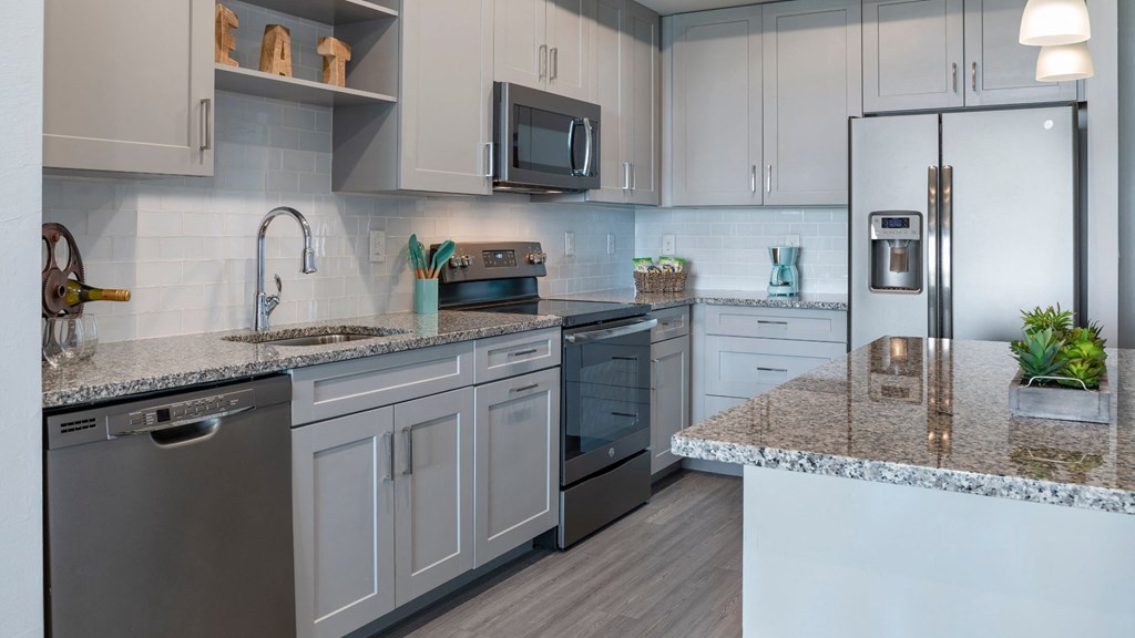 a kitchen with granite counter tops and stainless steel appliances