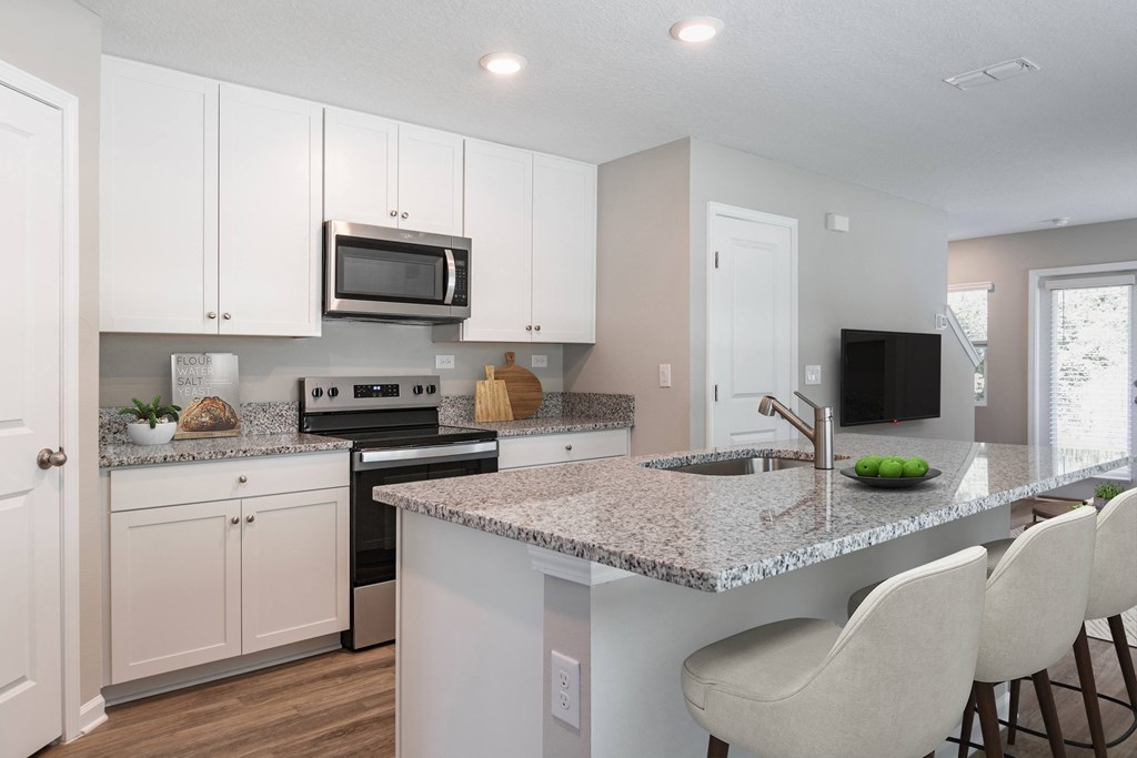 a kitchen with white cabinets and a granite counter top
