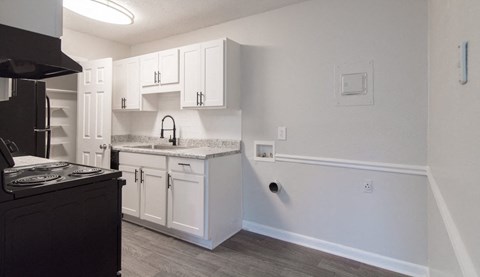 A kitchen with white cabinets and a black stove top oven.