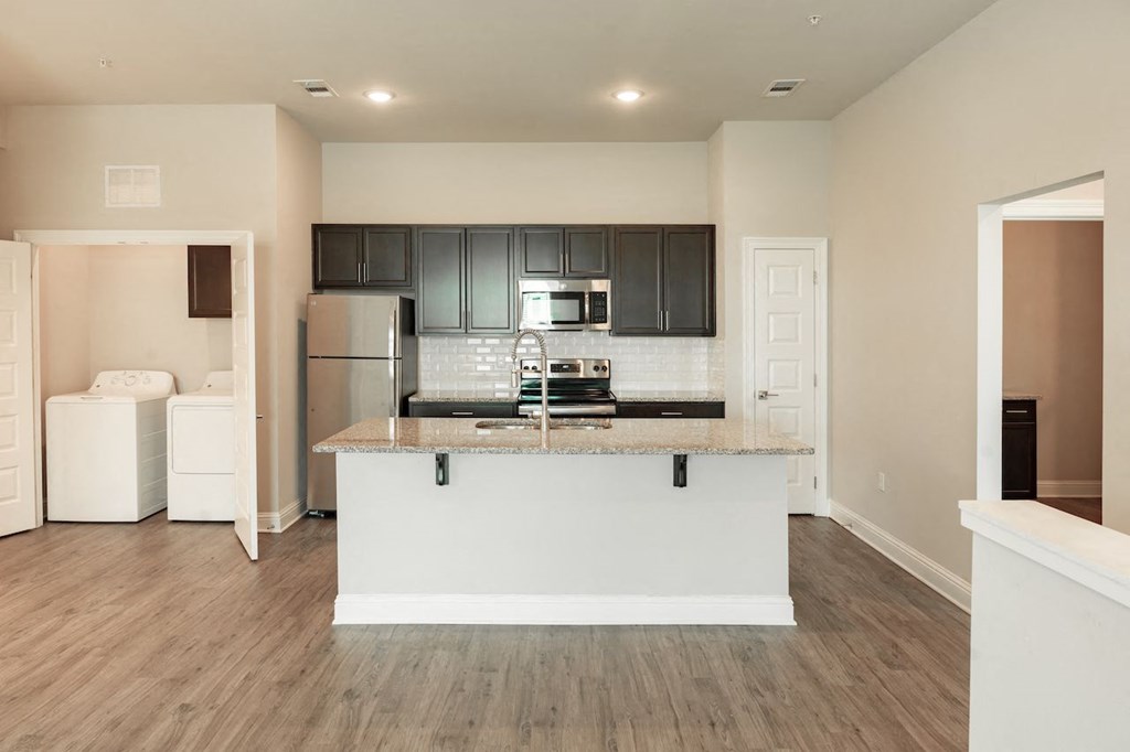 a kitchen with a large island with granite countertops