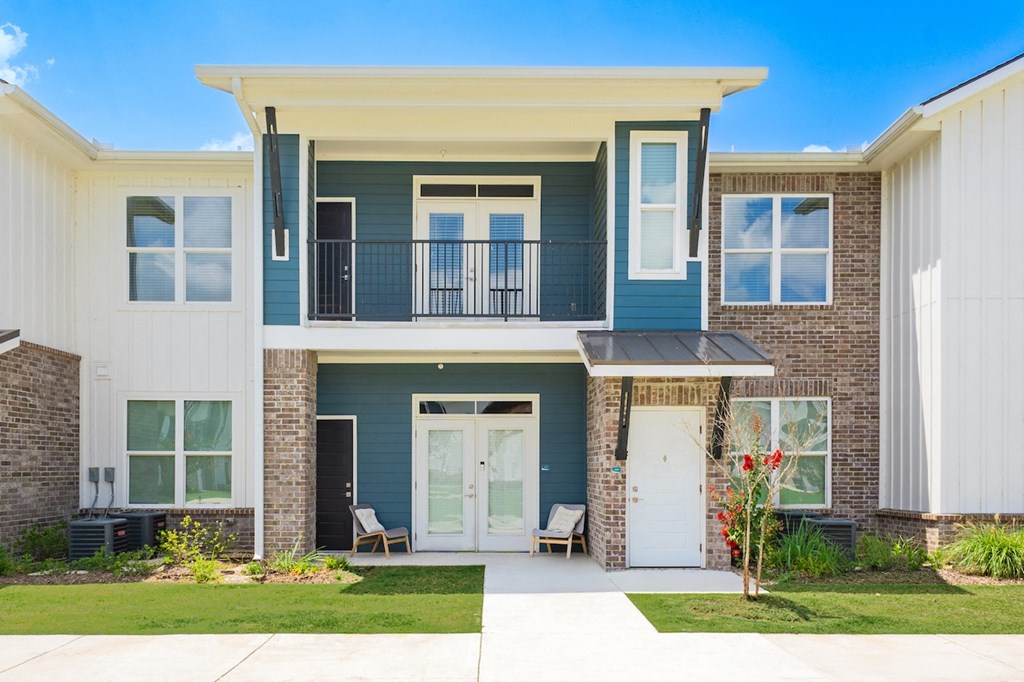 a blue house with a white door and a brick wall