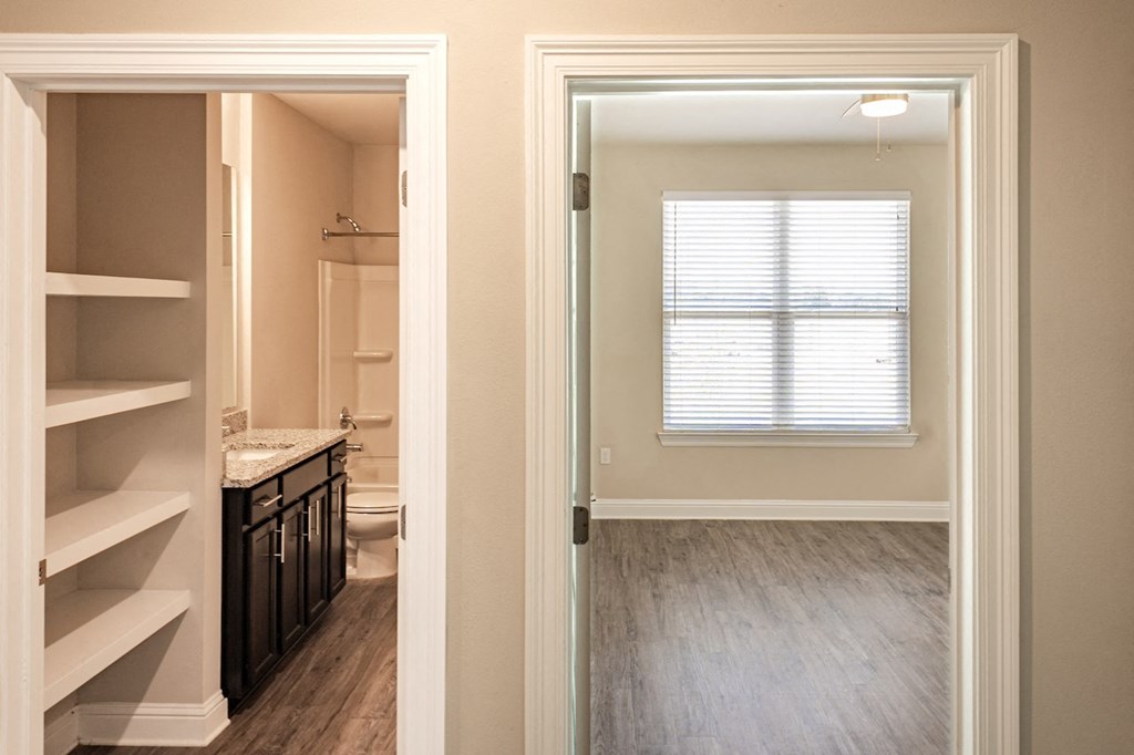 a bedroom with a large window next to a bathroom