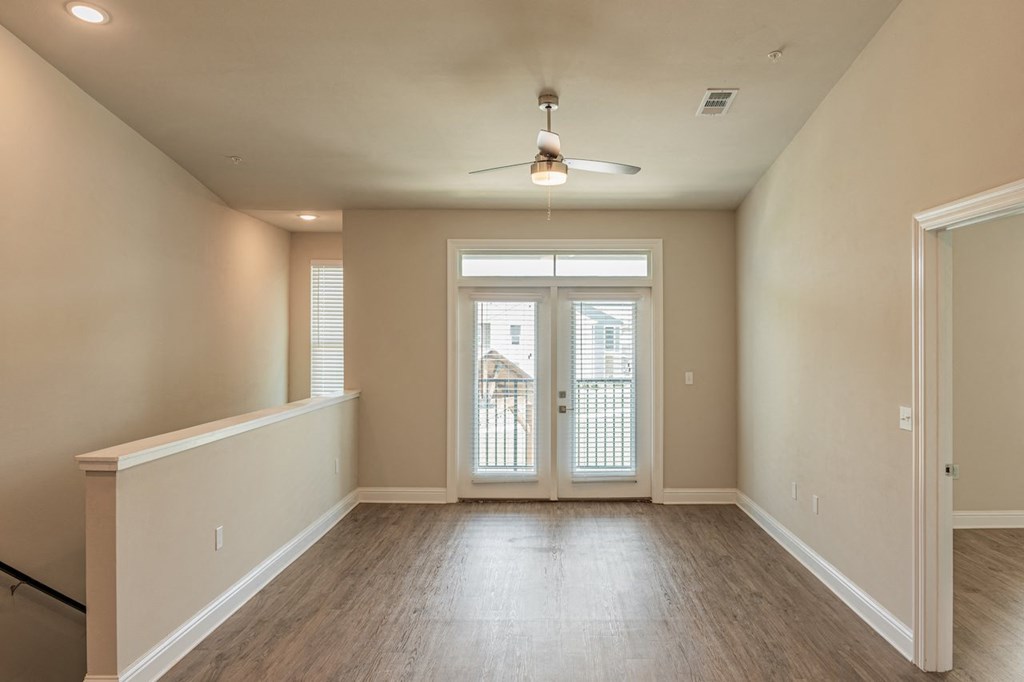 an empty living room with a ceiling fan