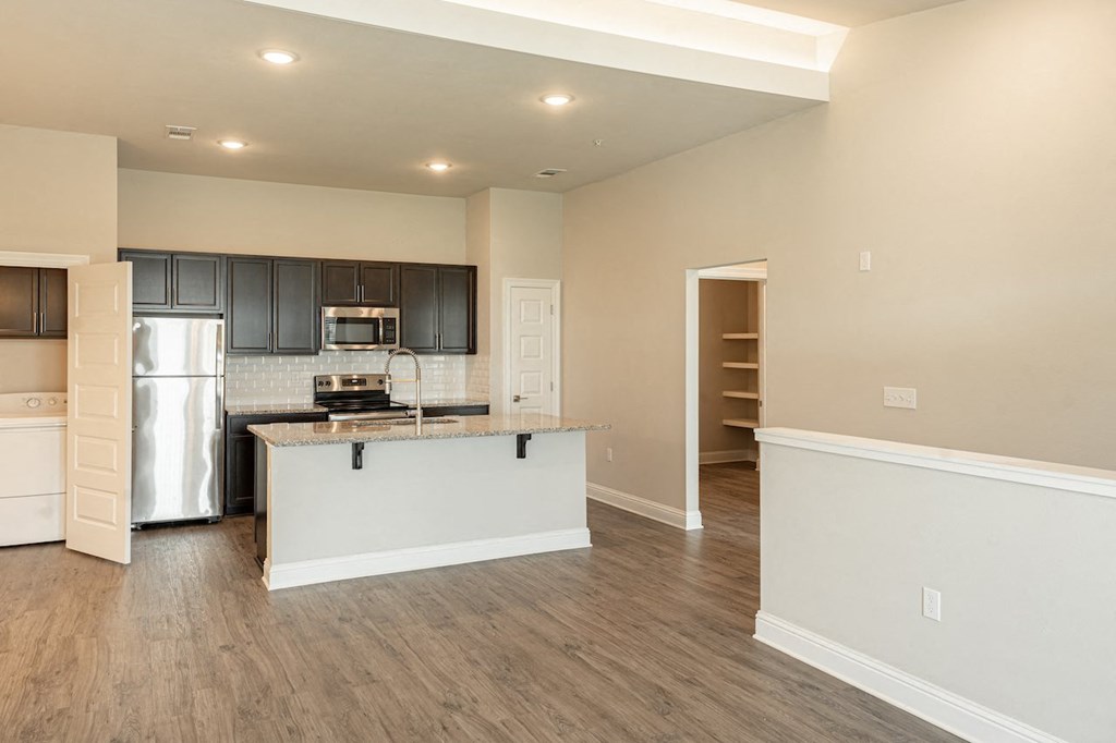 a kitchen and living room with a large island with granite countertops