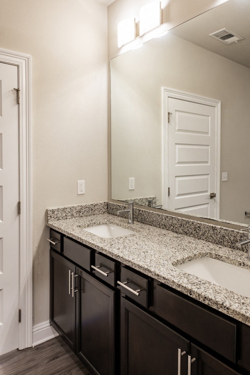 a bathroom with two sinks and a mirror
