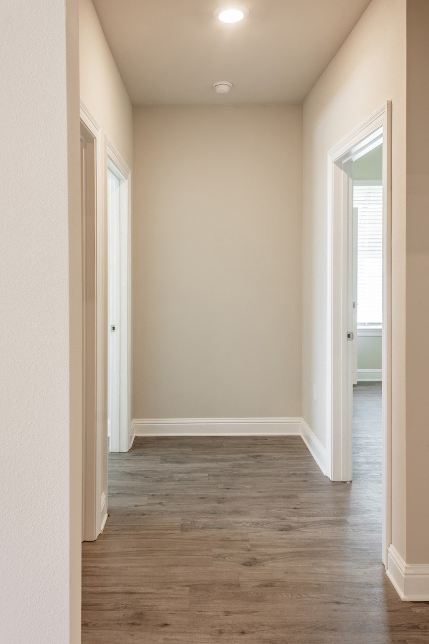 a hallway with wood floors and beige walls