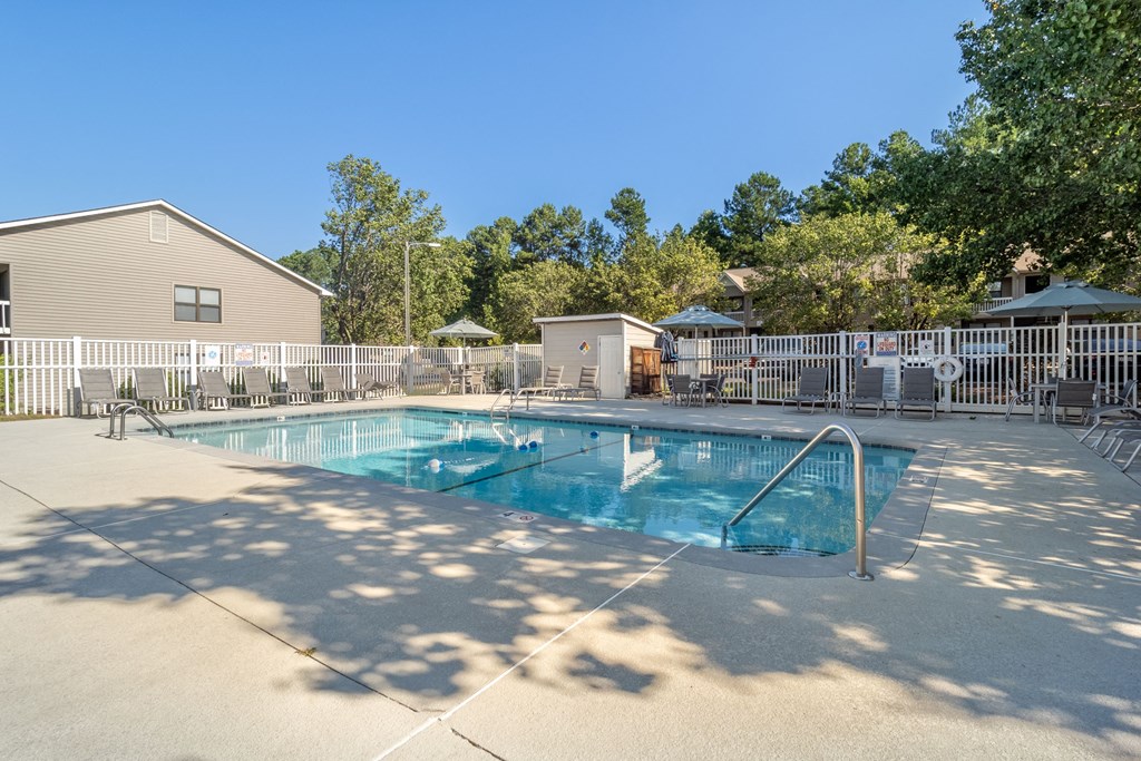 our resort style pool is surrounded by a fence and trees