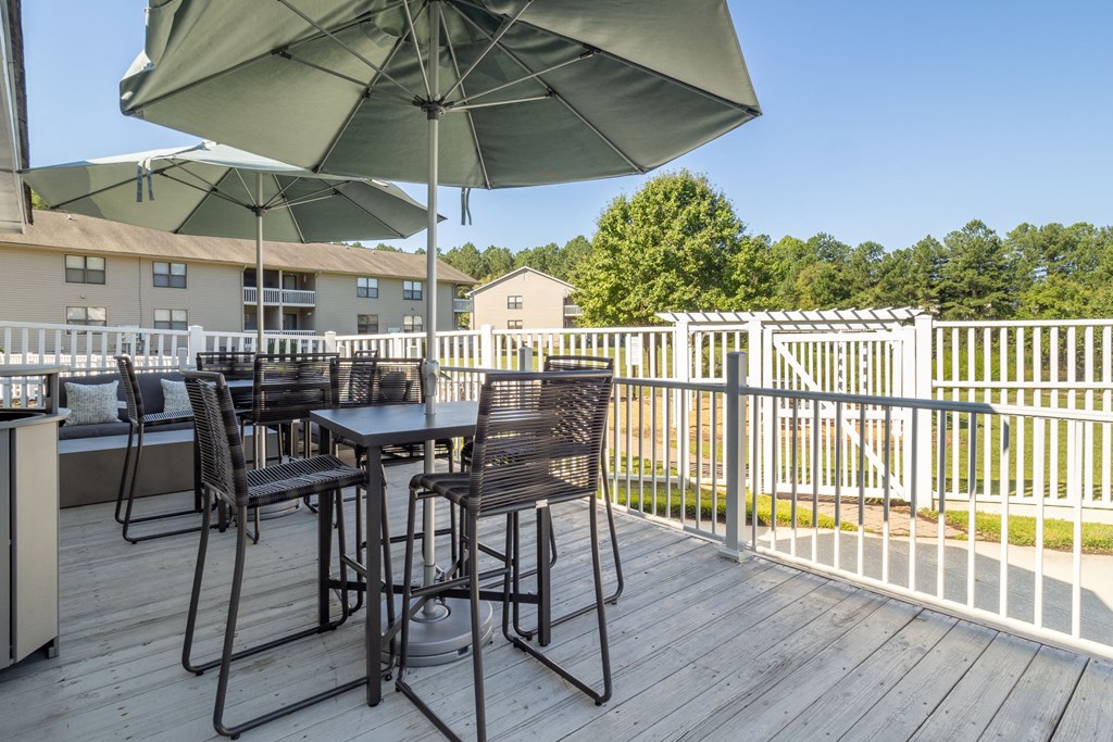 a patio with tables and chairs and umbrellas on a deck