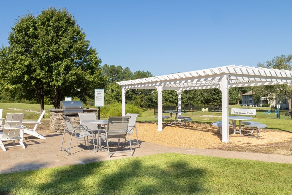 a picnic area with a table and chairs under a white canopy