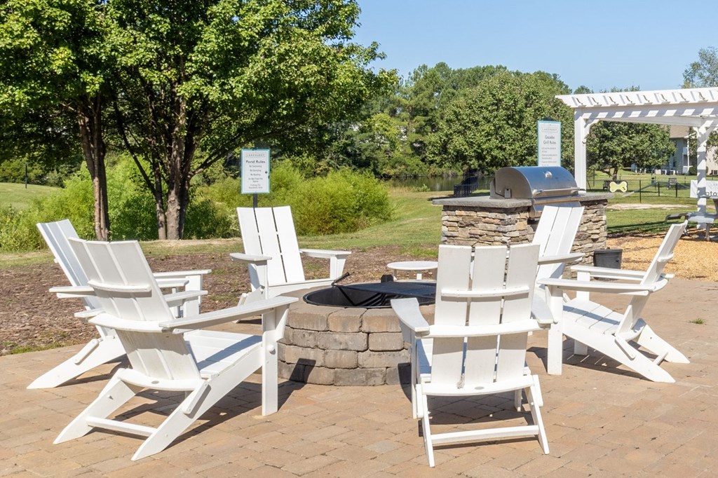 a group of white chairs sitting around a fire pit
