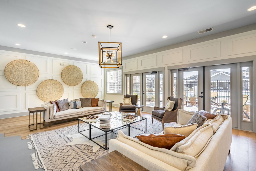 a living room with couches and chairs and glass doors