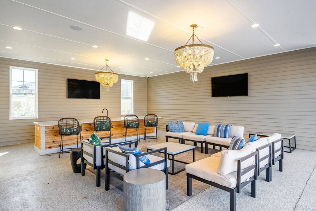 a living room with couches and chairs and two chandeliers