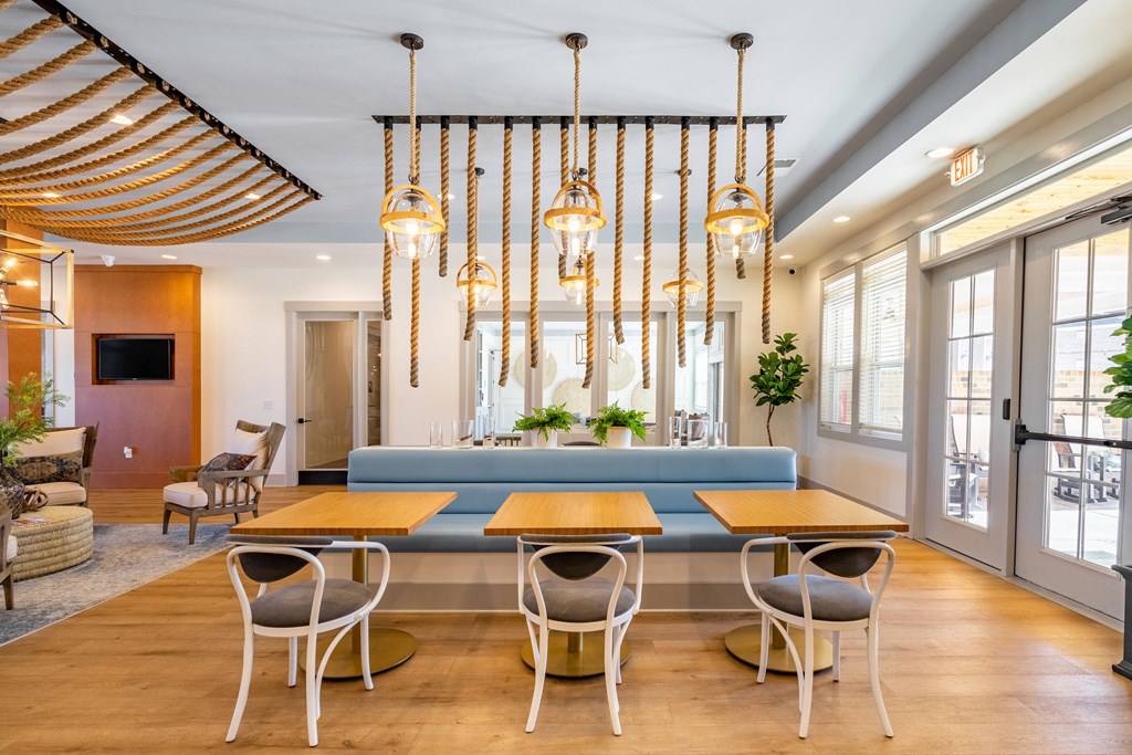 a living room with a blue couch and tables and chairs