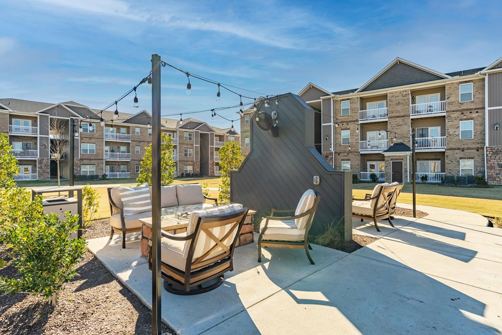 an outdoor patio with a table and chairs and an apartment building