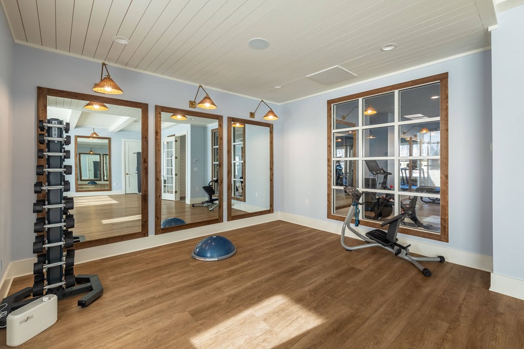 a workout room with a reformer chair and mirrors in a home gym