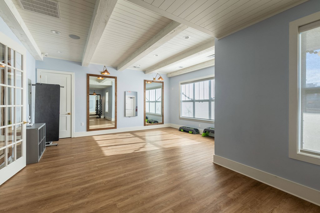 a living room with a hard wood floor and large windows
