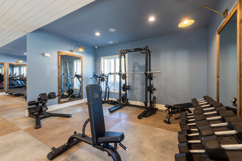 a gym with treadmills and other exercise equipment in a building with blue walls
