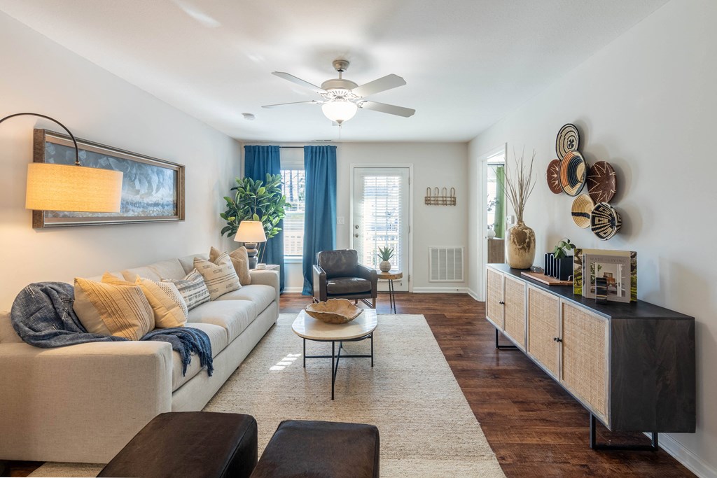 a living room with a white couch and a ceiling fan