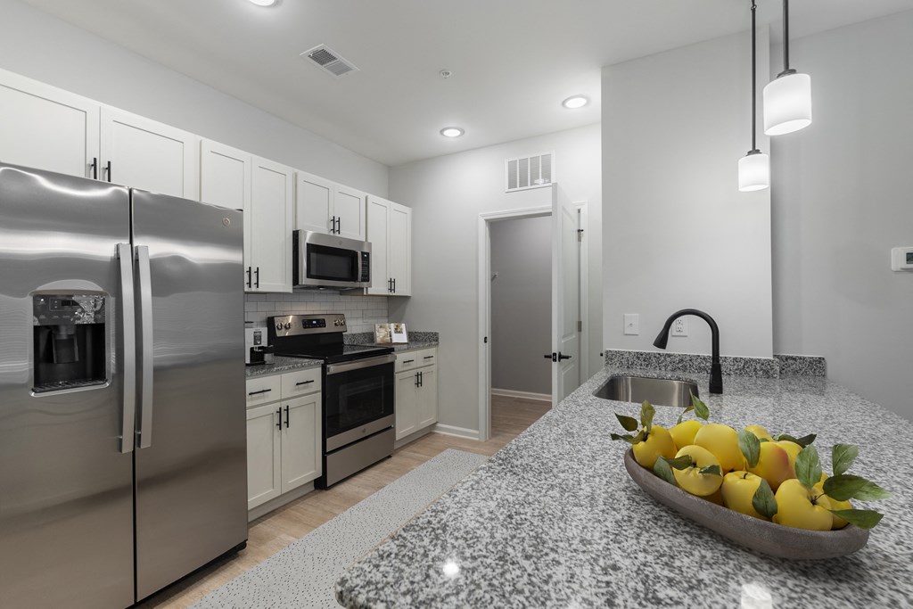 a kitchen with stainless steel appliances and a bowl of fruit
