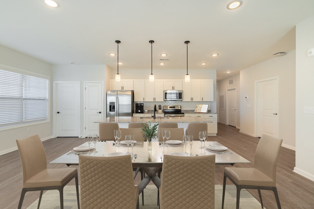 a dining room table with chairs in front of a kitchen