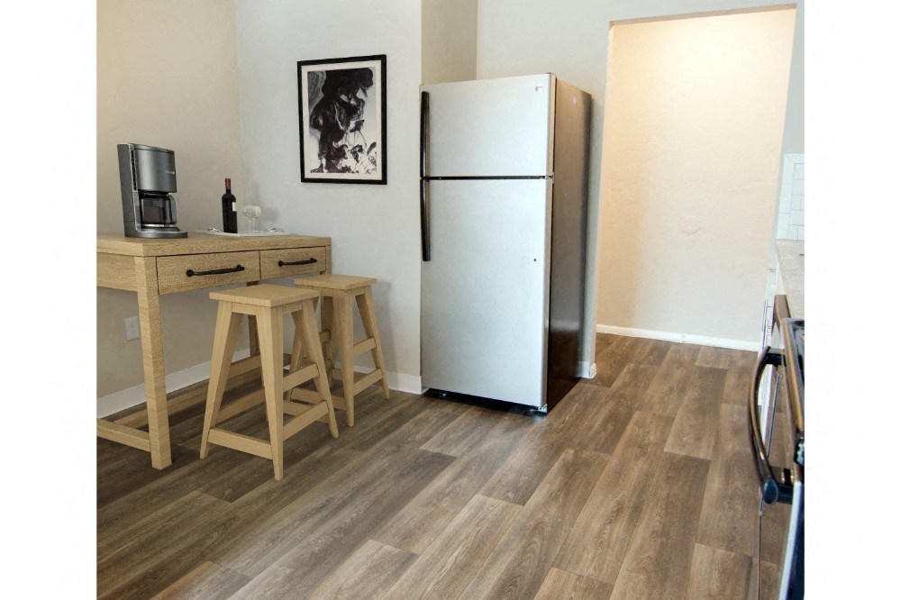 a kitchen with a refrigerator and a counter with stools
