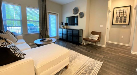 A living room with a white couch and a black and white striped throw pillow.