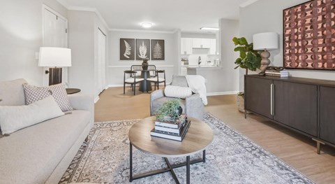 A living room with a white couch, a coffee table, and a large painting on the wall.