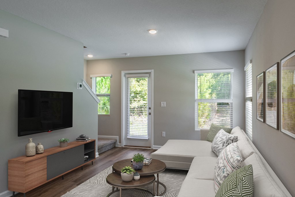 a living room with a white couch and a television