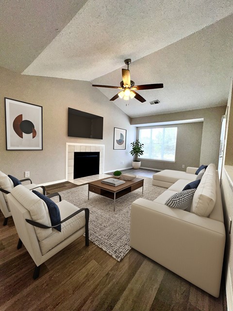 a living room with white furniture and a ceiling fan