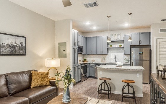 a living room with a couch and a kitchen with a sink