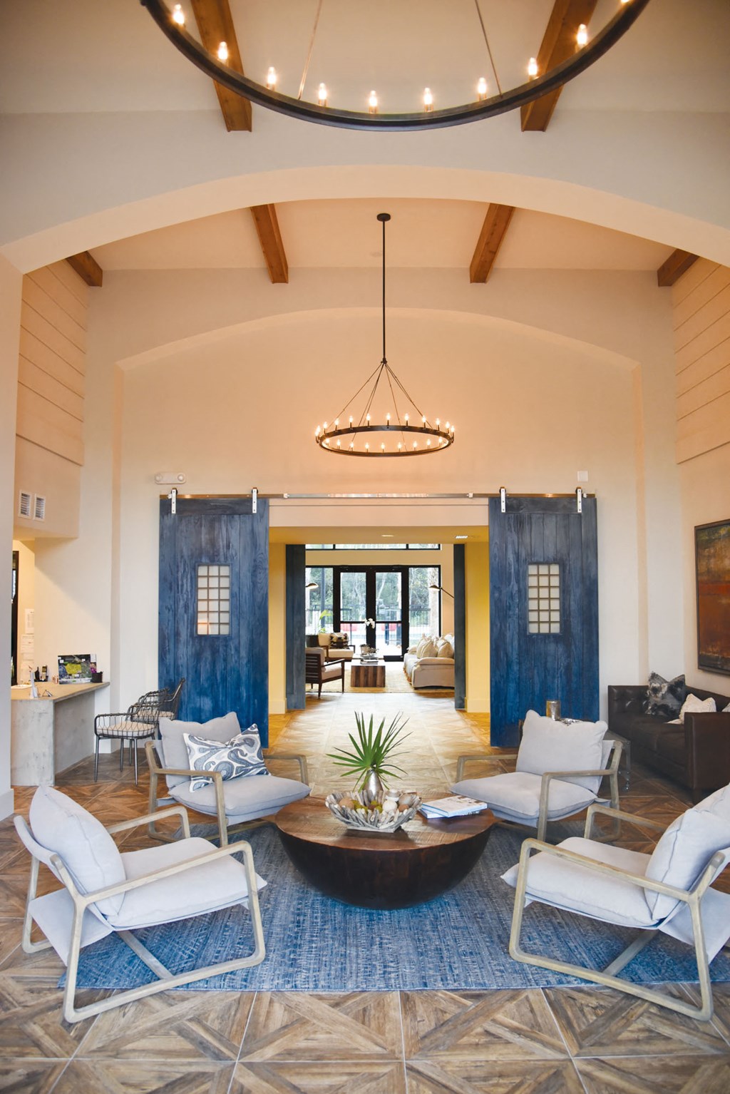 a living room with white chairs and a blue rug and a round table