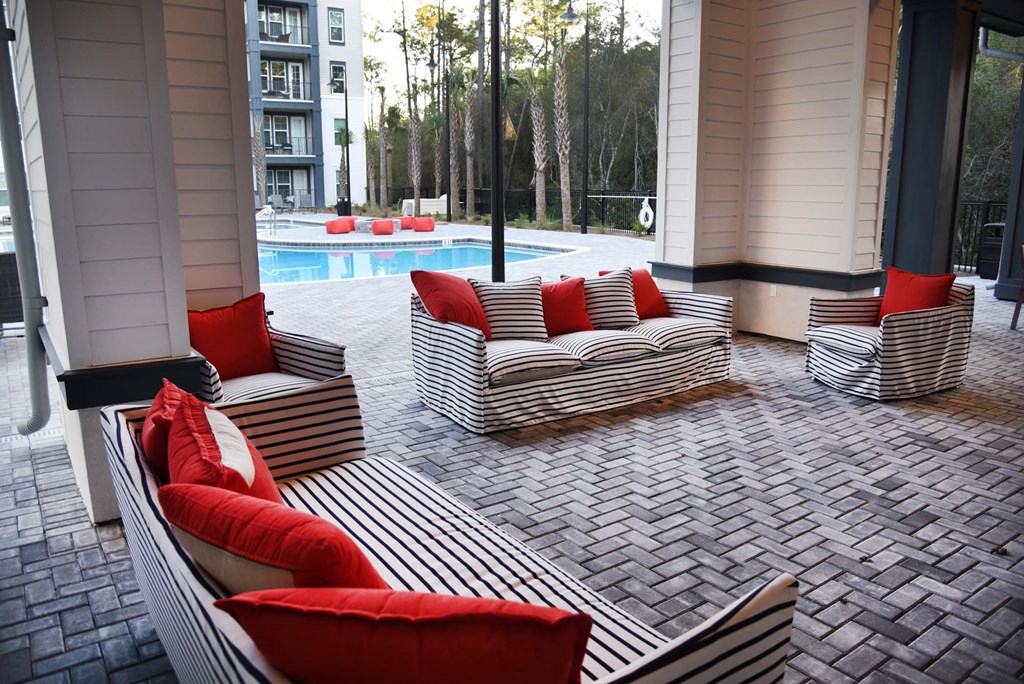 a patio with couches and chairs near a pool