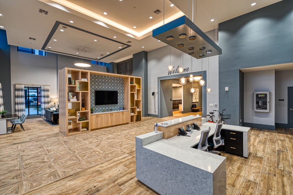 a large lobby with a reception desk and a tv