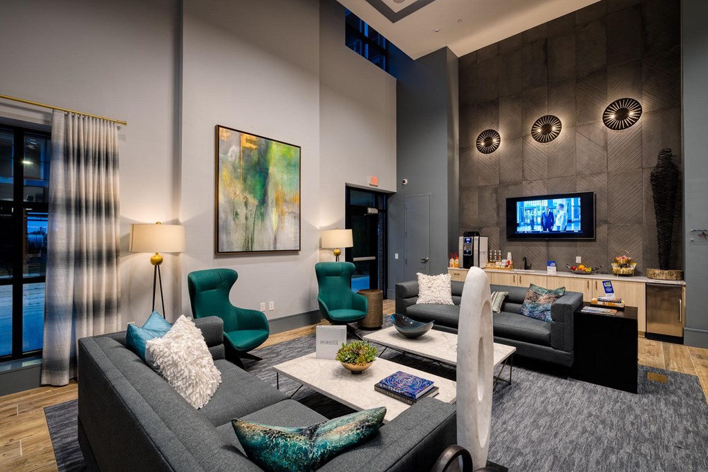 a living room with couches and chairs and a television