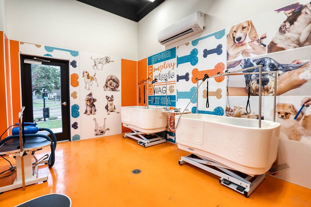 a bathroom with two sinks and a mural of dogs on the wall