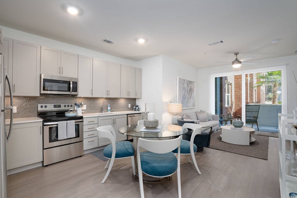 a kitchen and living room with a table and chairs