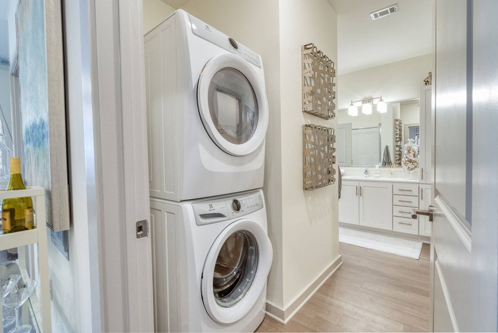 a white washer and dryer in a bathroom with a sink