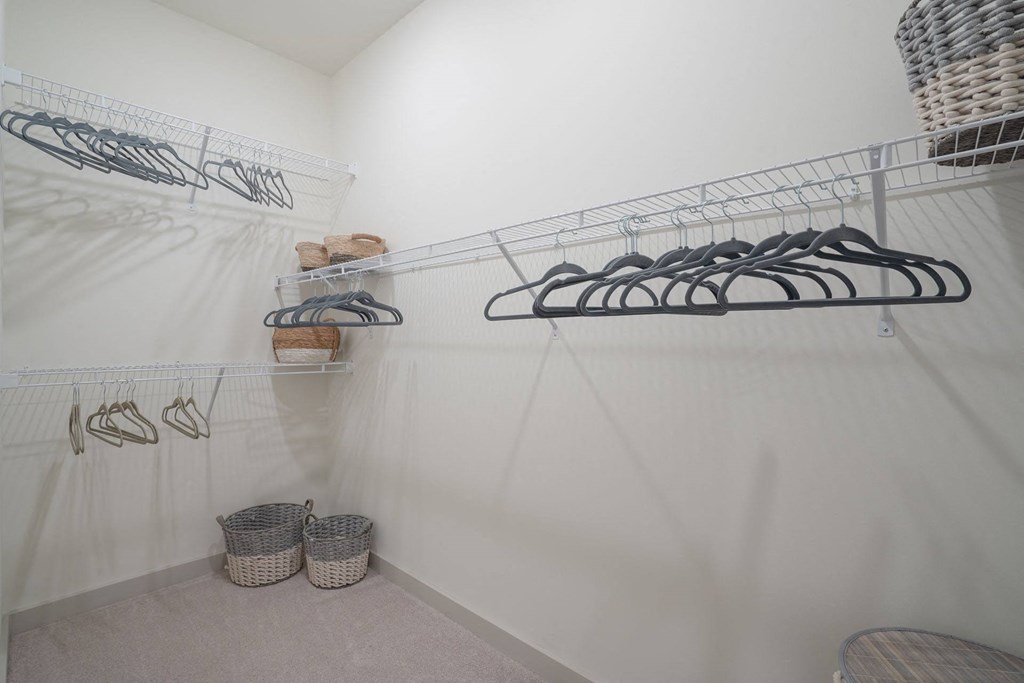 a walk in closet with shoe racks on the wall