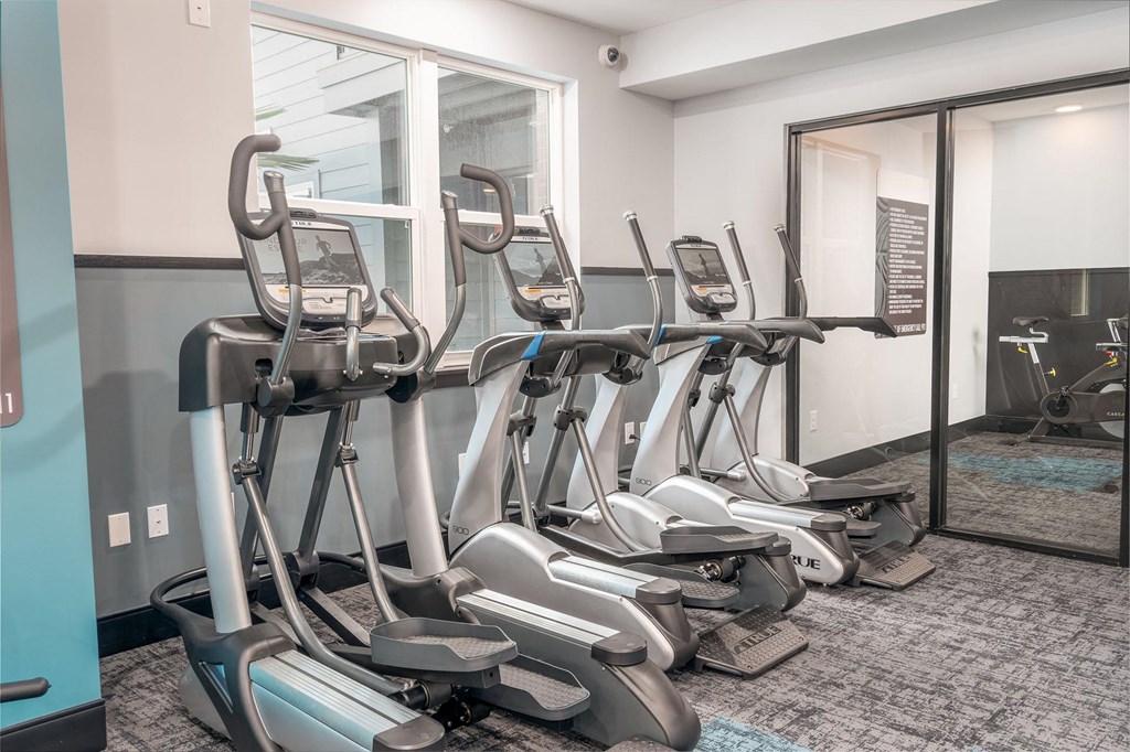 a gym with cardio equipment at the district flats apartments in lenexa