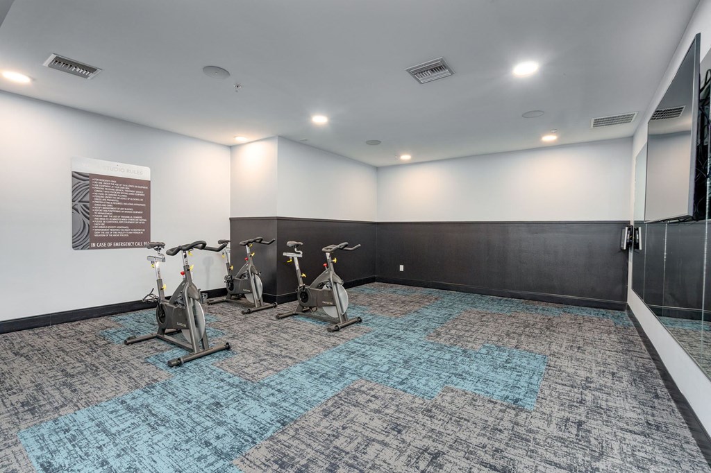 a gym with three exercise bikes in the corner of a room
