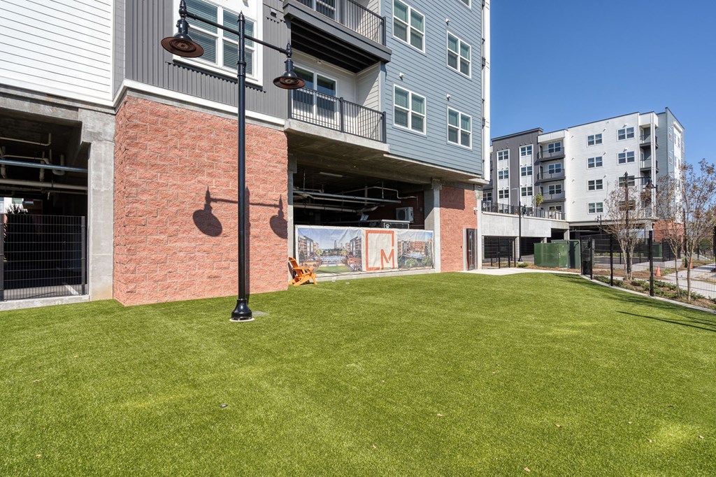 the yard of an apartment building with a green lawn