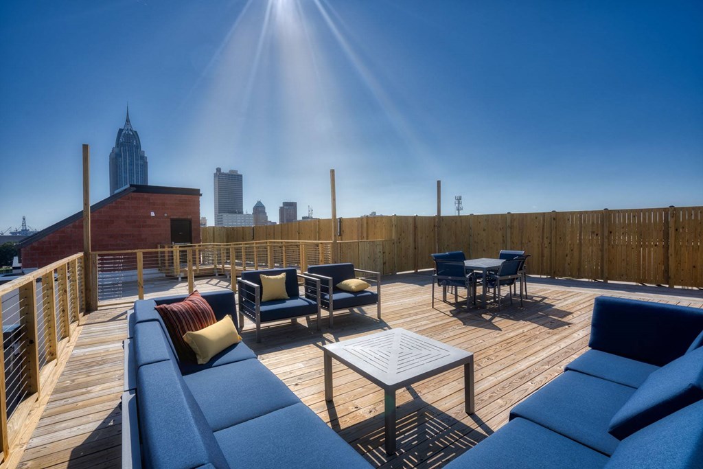 the deck on the top of the building has couches and tables