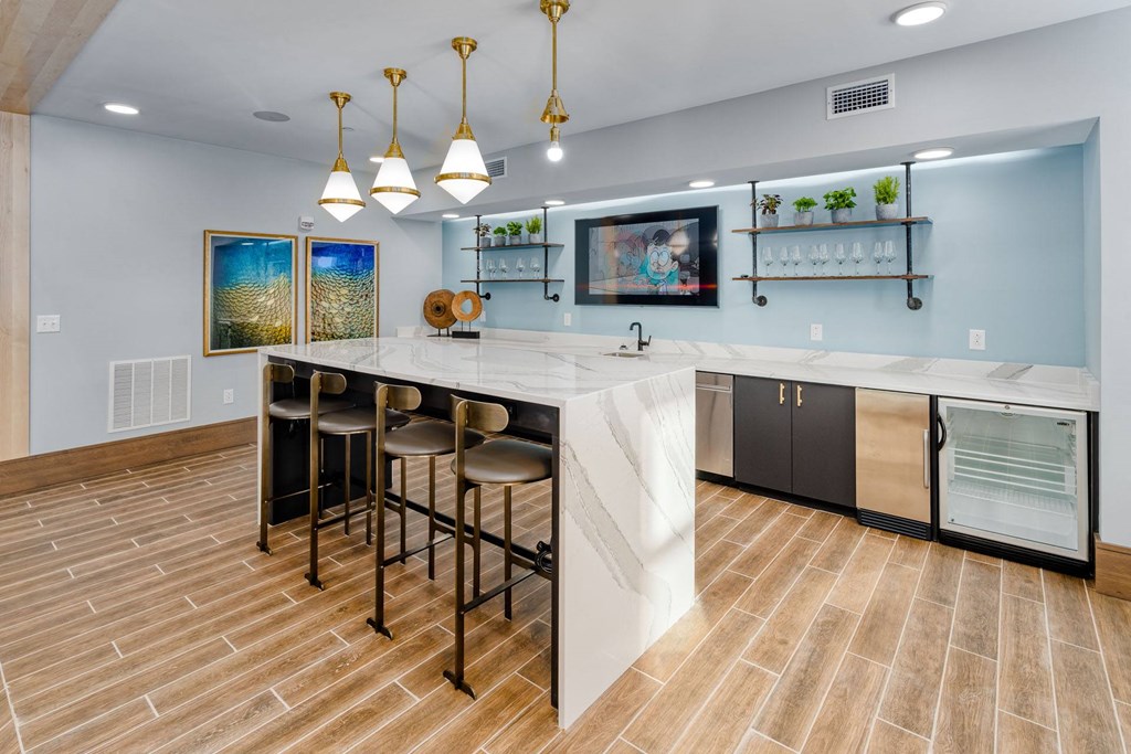 a large kitchen with a marble counter top and bar stools