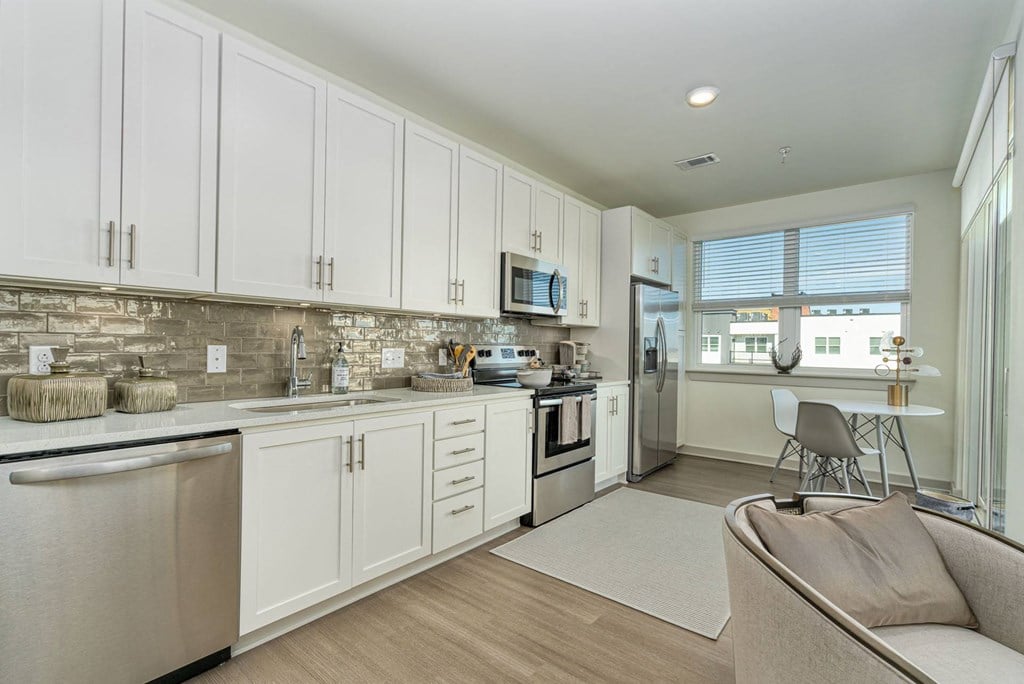 a kitchen with white cabinets and a counter top