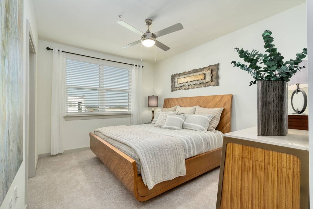 a bedroom with a bed and a ceiling fan