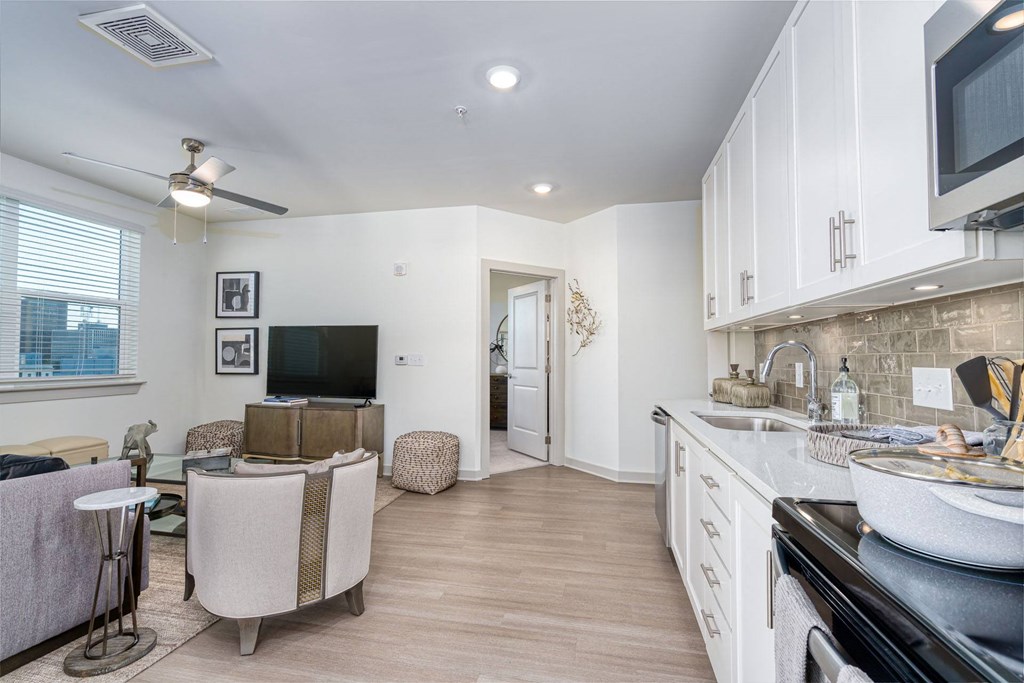 a kitchen and living room with white cabinets and a tv