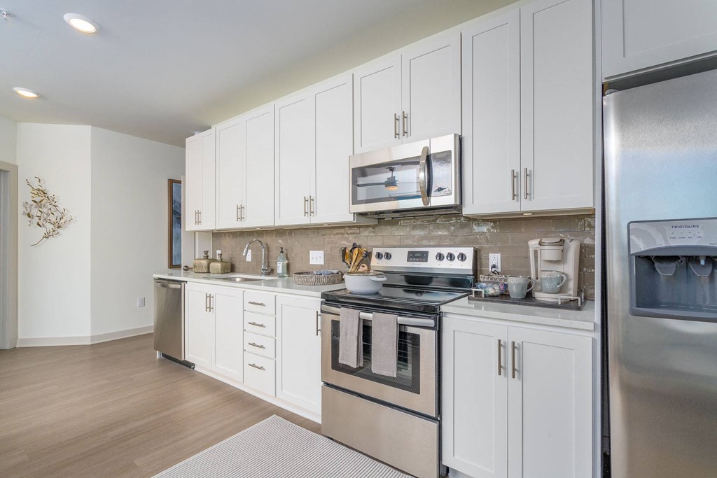 a kitchen with white cabinets and stainless steel appliances
