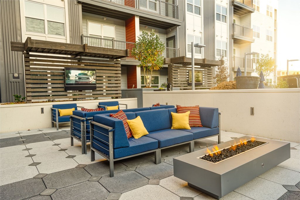 a patio with a couch and chairs and a fire pit